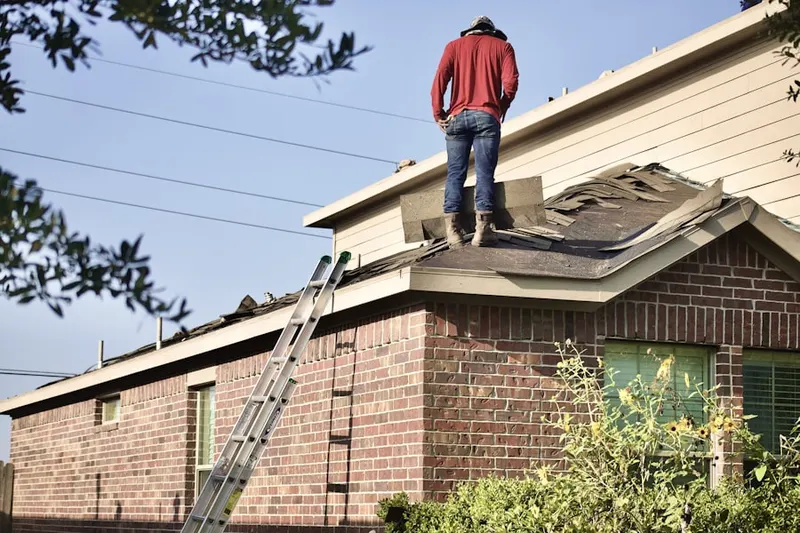 Professional roofer working on a residential roof in The Hills at Cherry Creek